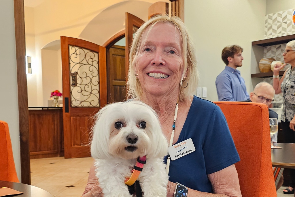 Bella Vida VIP holding a puppy.