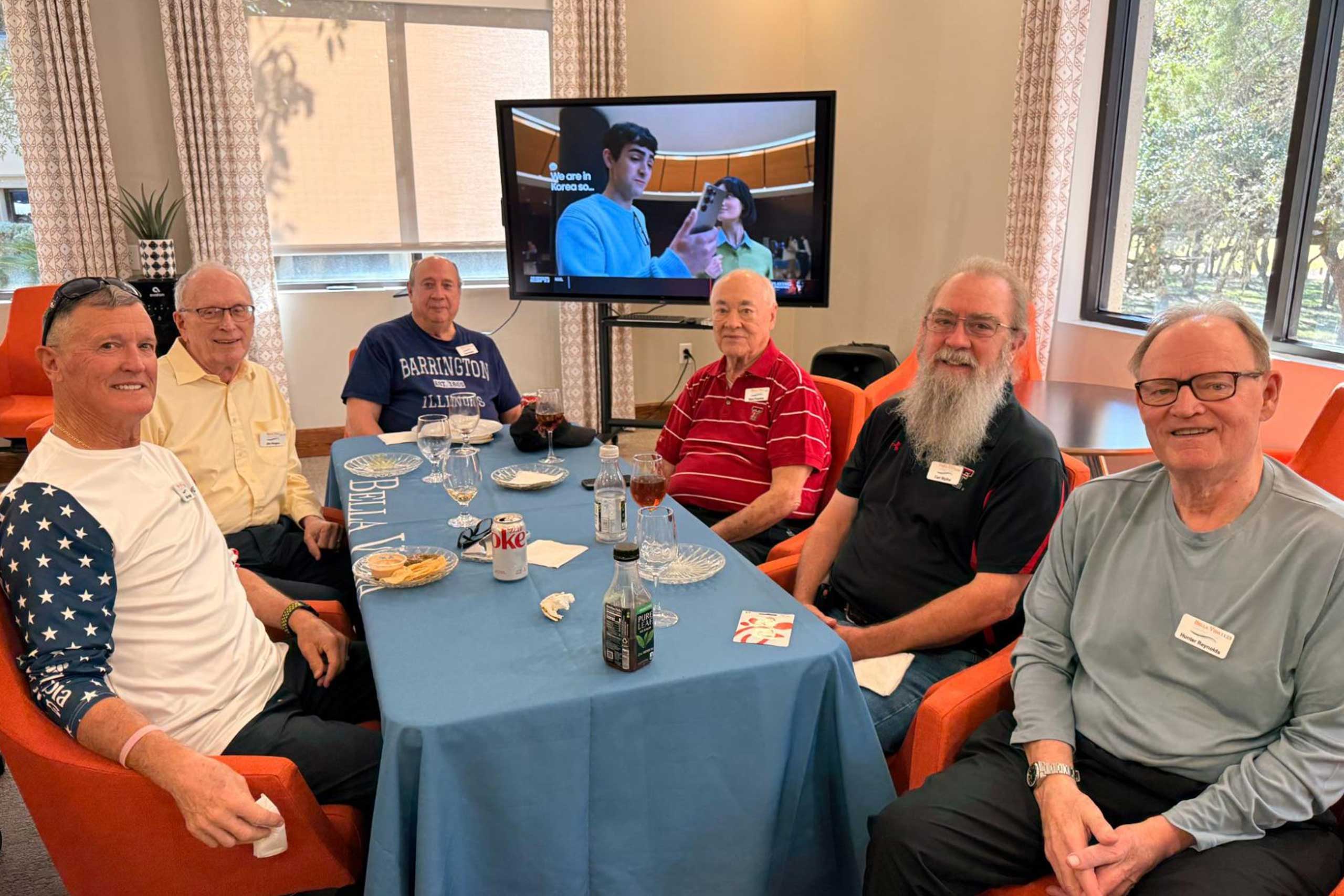 Male VIPs enjoying a game-day event, watching the Myrtle Beach Bowl between Kennesaw State and Western Michigan, playing Football Squares, and sharing food and prizes.