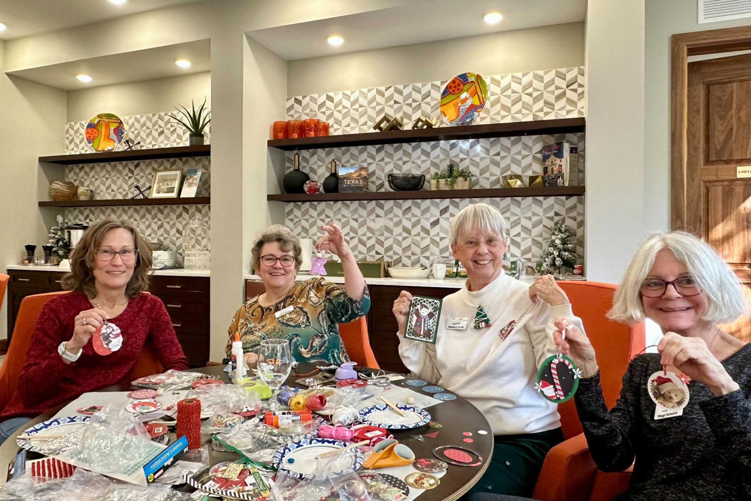 VIPs crafting holiday gifts, cards, and gift tags together during a festive community event.