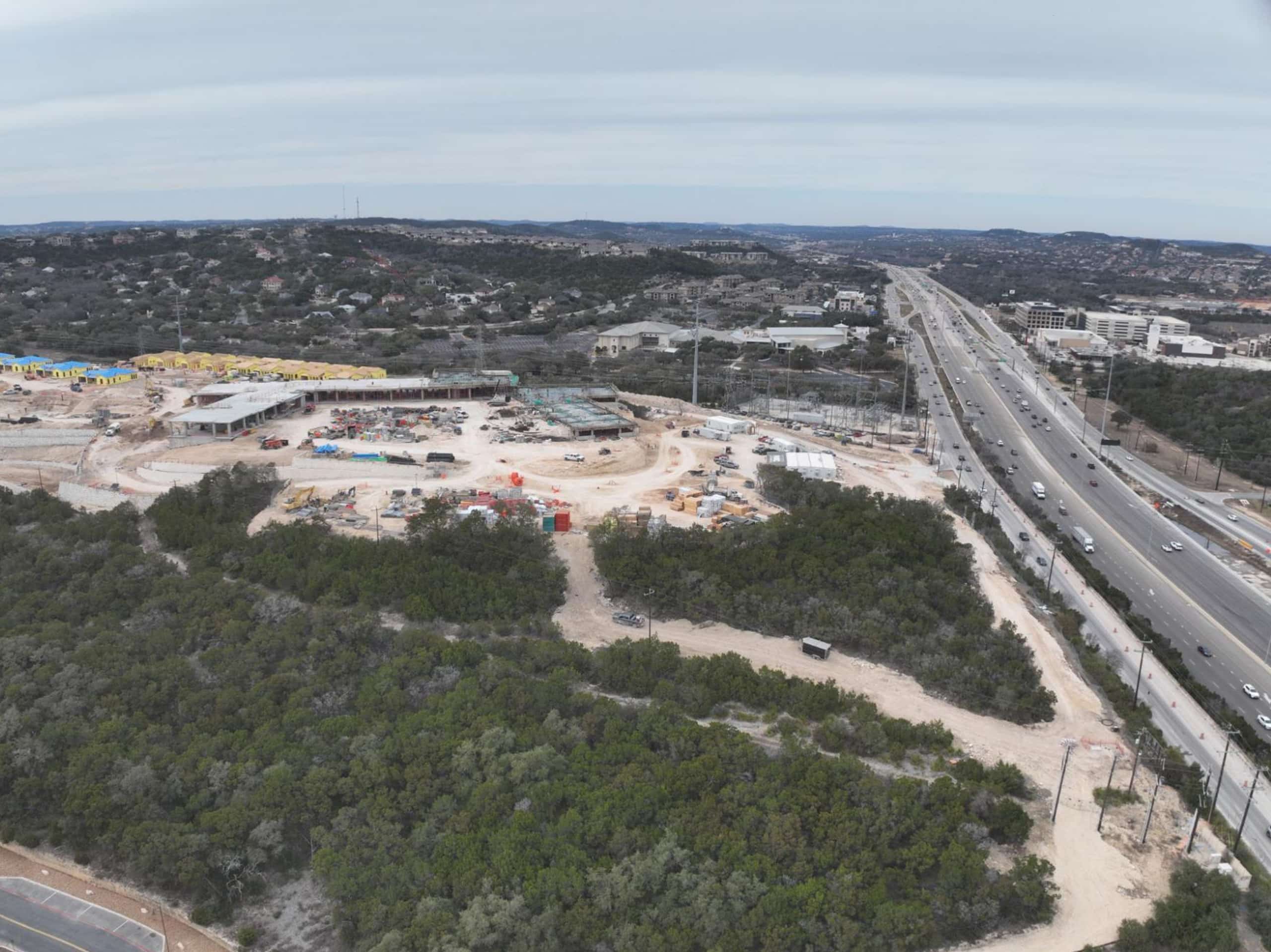 Bella Vida construction site with crews working on site walls, utilities, concrete slabs, and new framing at the Memory Care building, Phase 3 villas, and quadplex foundations.